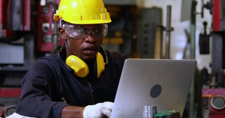Manufacturing Factory black male Mechanical Engineer Works on Personal Computer at Metal lathe industrial manufacturing factory. Engineer Operating lathe Machinery. American African people. - Powered by Adobe