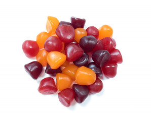 Close-up texture of red, orange and purple multivitamin gummies on white background. Healthy lifestyle concept..