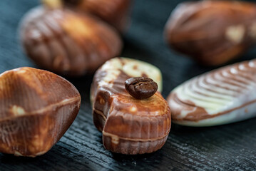 Figures of Belgian chocolate on a dark wooden background close-up.