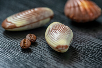 Figures of Belgian chocolate on a dark wooden background close-up.