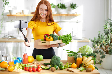 Redhead female preparing healthy lunch for family in modern kitchen, taking vegetables