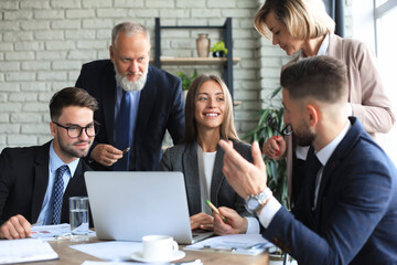 Fototapeta premium Startup business team on meeting in modern bright office interior and working on laptop.