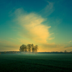 Beautiful clouds over the springtime scenery during the sunrise. Dramatic, colorful look. Rural landscape of Northern Europe.