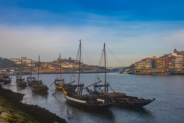 Traditional boats with barrels on the Douro river, Ribeira and Dom Luis bridge, Porto, Portugal.