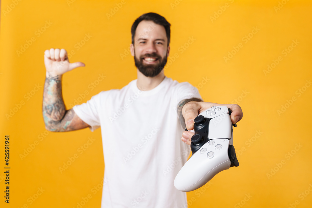 Wall mural Happy mid aged brunette bearded man holding joystick