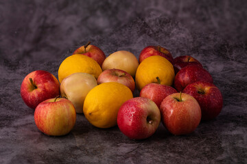 Red apples are scattered on the gray marble table.