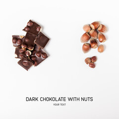 pieces of dark chocolate with whole nuts on the white background