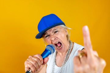 Funny portrait of mature woman. Lady having fun dressed as an angry rapper - obrazy, fototapety, plakaty
