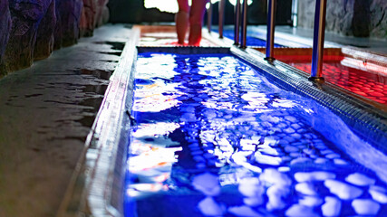 Kneipp walking therapy in hot and cold water in spa wellness center. Healing power of the water. The Kneipp route as an holistic treatment in naturopathy. Rehabilitation water treatments in pool.