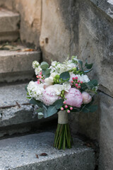Fototapeta na wymiar Pink wedding bouquet, composed of roses, freesias, peonies, hypericum, astilba and eucalypthus.