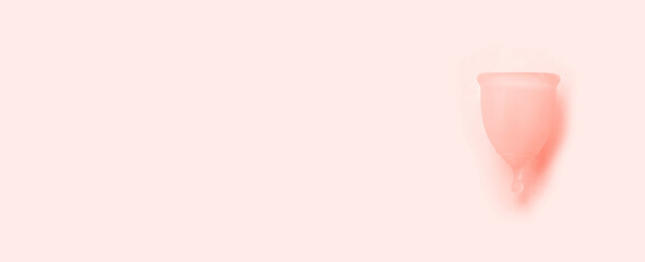 Concept of critical days, menstruation. Bio silicone menstrual cup on a pink background.