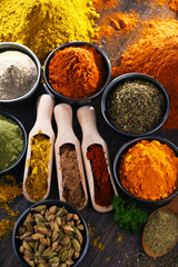 Variety of spices on wooden kitchen table.