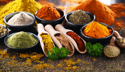 Variety of spices on wooden kitchen table.