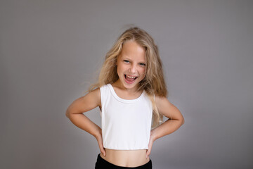 Portrait of a pretty little blonde girl showing emotions and screaming