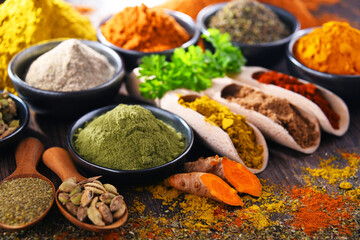 Variety of spices on wooden kitchen table.
