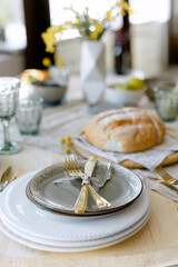 Golden knife and fork on a ceramic plate kitchen table in an apartment