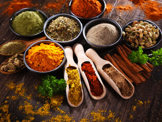Variety of spices on wooden kitchen table.