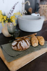 Fresh bread on the table eco tray Stylish kitchen Flowers in a jug