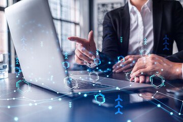 Two information technology specialist brainstorming on project to create a new approach to develop software to improve business service. Working with laptop. Tech hologram icons.