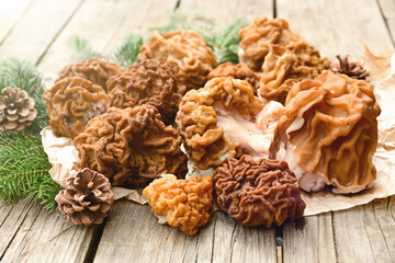 A few morel mushrooms lie on a wooden table. Outdoors.