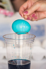 close up of a hand holding dipping Easter egg