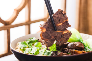 Spicy red soup beef noodle in a bowl on wooden table