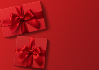 Two red gift boxes on red background flat lay, present box top view	