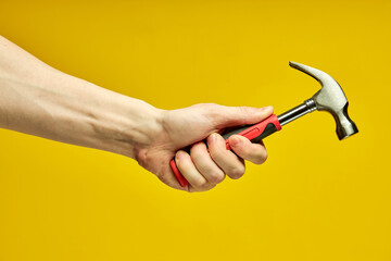 close-up hammer with rubberized handle in cropped male hands