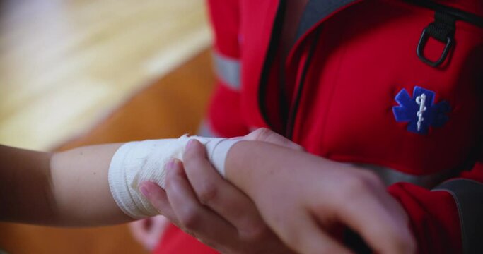 Doctor wrapping bandage on injured hand, closeup view
