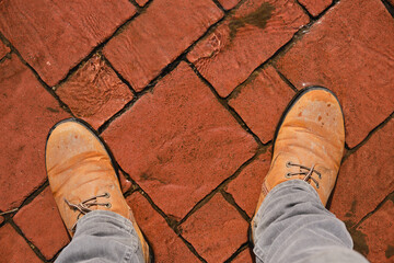 In boots on red cobblestones flooded with thawed spring water.