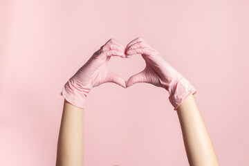 Heart shaped hands of nurse with exam gloves on