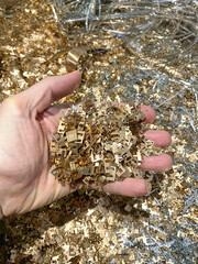 Hand holding bronze scrap cuttings.