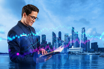 A young eastern handsome trader in suit examine his notes to predict the market behavior based on...