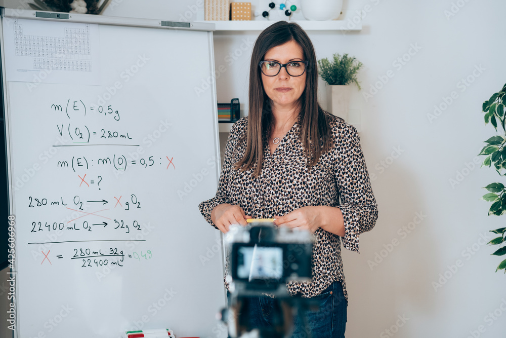 Wall mural teacher recording video tutorial for e-learning class. female professor working from home teaching o