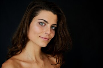 Fototapeta premium Young Polish woman in studio with black background. Portrait with gentle smile.
