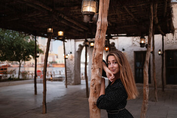 Happy woman traveler wearing black dress walking through the streets