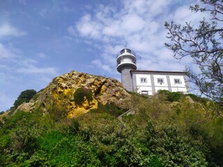 a white lighthouse on the mountain a blue sky day in spring in Guetaria, Basque Country, Spain