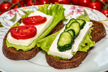 sandwich with cheese, lettuce and tomato on a wooden table