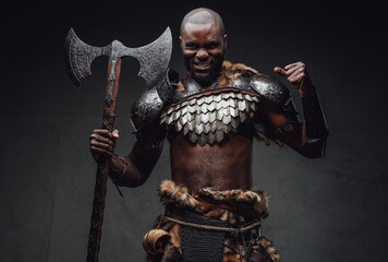 Rabid african warrior in steel armor and fur wielding an axe in studio