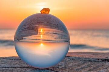 Ostsee -Strand in der Glaskugel im Gegenlicht mit durchleuchteten Bernstein im Sonnenuntergang