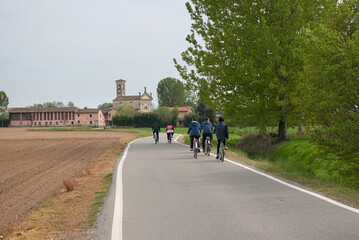 persone in bicicletta nella strada di campagna