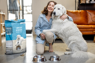 Woman feeding dog with a dry food at home