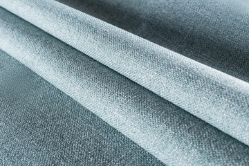 dense upholstery fabric of pale blue with a linen texture, drapery folds