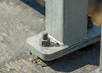 Close up iron pillar bolted to concrete bridge foundation