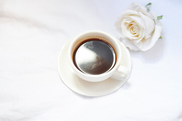 cup of coffee with white roses in the morning
