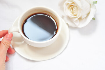cup of coffee with white roses in the morning