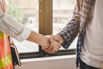 Close up hand of young contractor, engineer handshake with partnership, customer after agreement to work together at the site, workplace,business success concept.