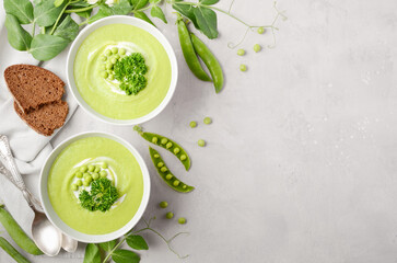 Green pea soup in a bowls on gray concrete or stone background Top view Flat lay Copy space