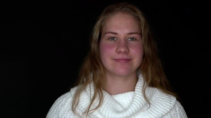 Smiling corpulent girl is laughing at the camera. Woman portrait on a black background.