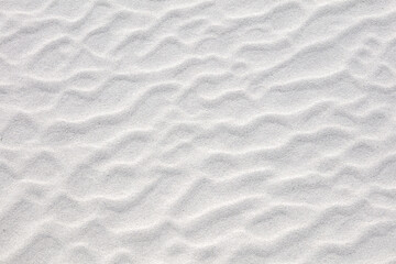 Fototapeta na wymiar Abstract irregular pattern in white sand on beach. Textured summer background.
